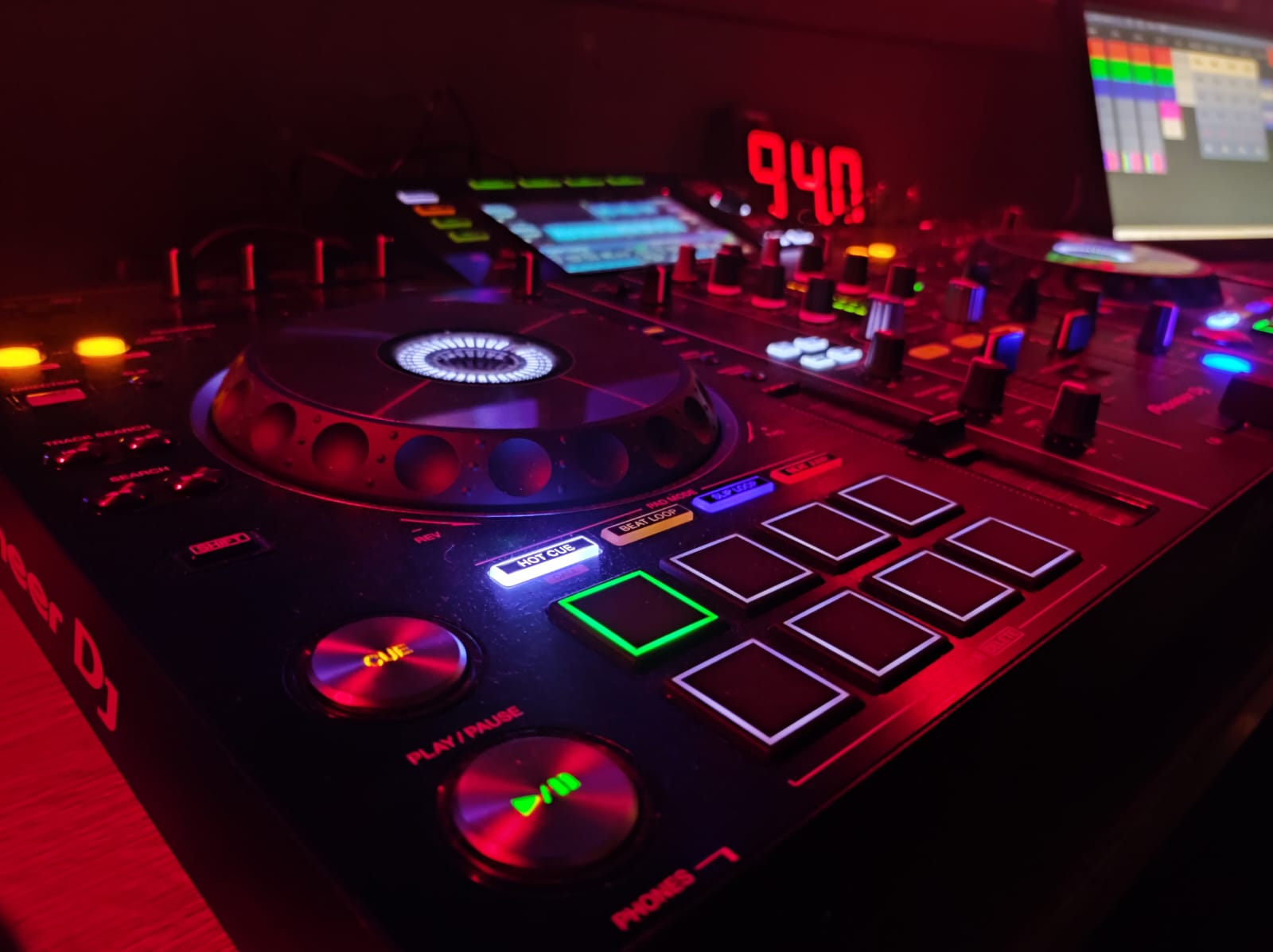 Detailaufnahme des DJ-Setups im roten Licht